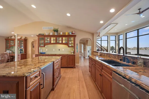 a kitchen with stainless steel appliances granite countertop lots of counter top space and wooden floor