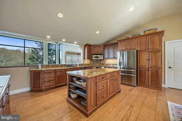 a kitchen with a stove a refrigerator and a wooden floor