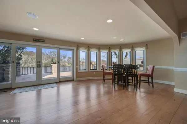 a view of living room with kitchen island stainless steel appliances and wooden floor