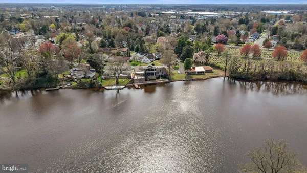 an aerial view of residential houses with outdoor space and lake view