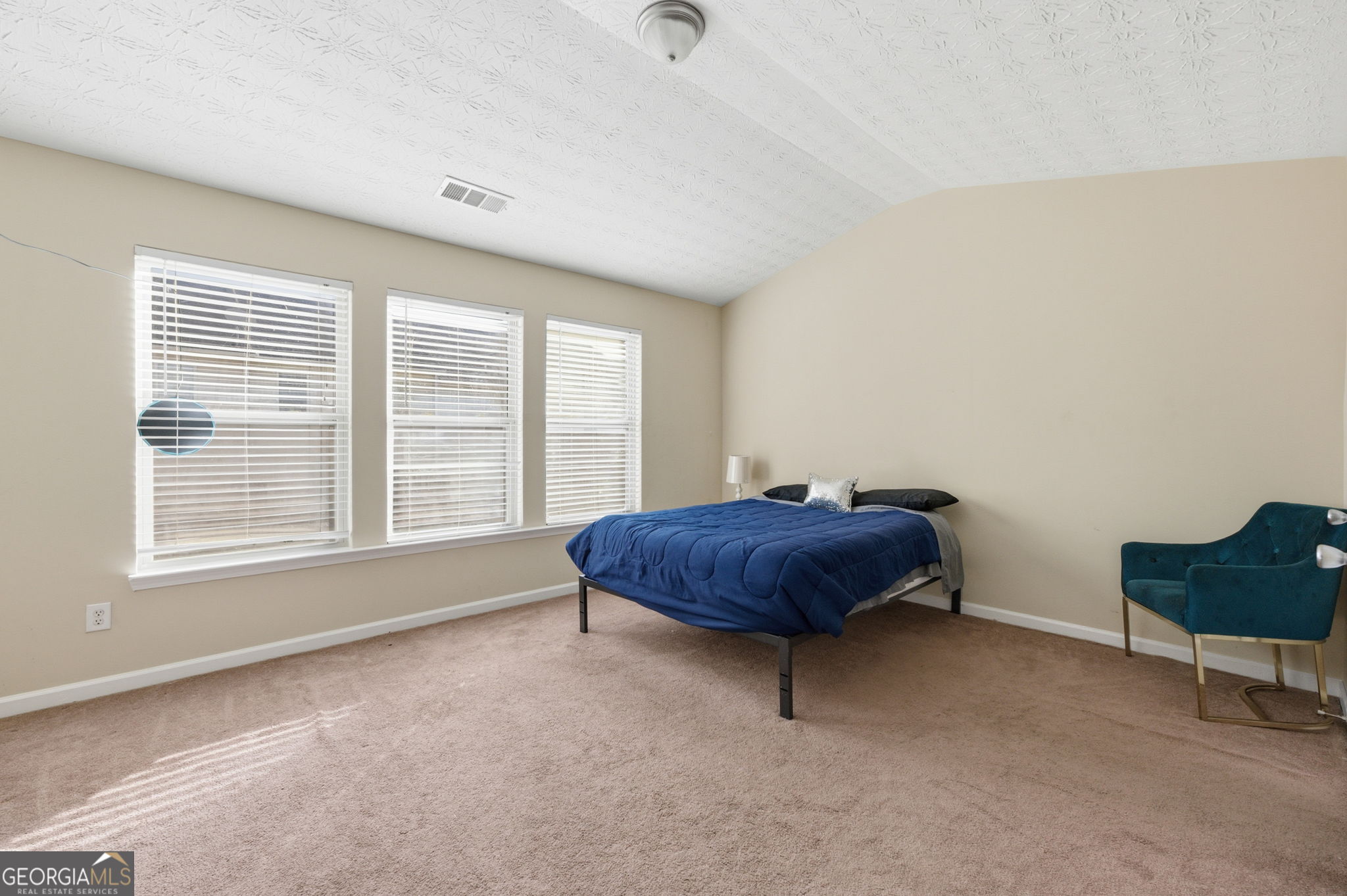 6022 Centennial Run Atlanta, GA 30349 - Photo 14 of 23 a spacious bedroom with a bed and a chair