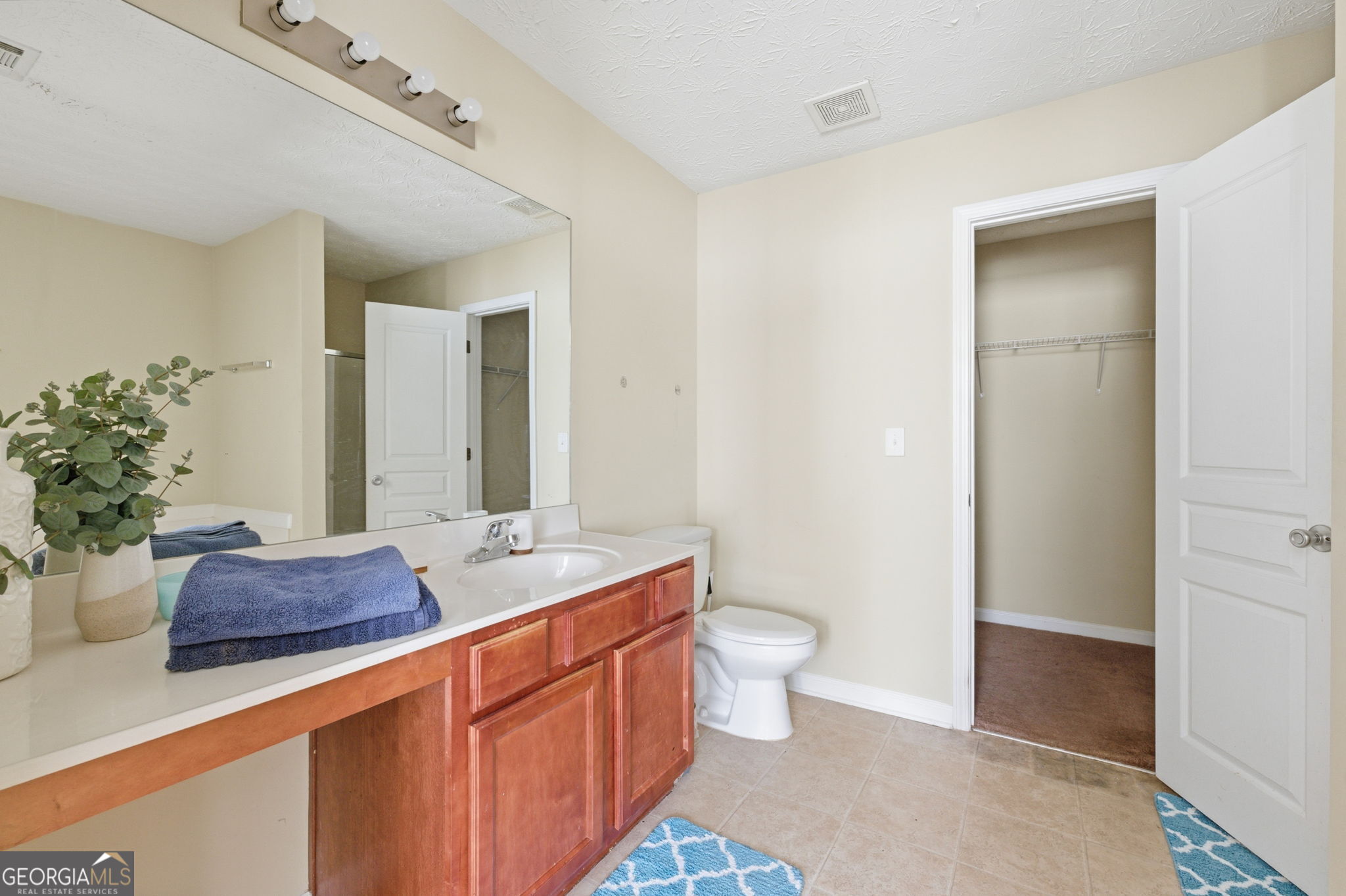 6022 Centennial Run Atlanta, GA 30349 - Photo 17 of 23 a spacious bathroom with a granite countertop sink and a mirror