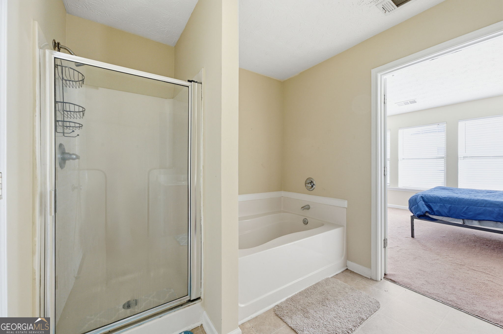 6022 Centennial Run Atlanta, GA 30349 - Photo 18 of 23 a bathroom with a bathtub and a shower