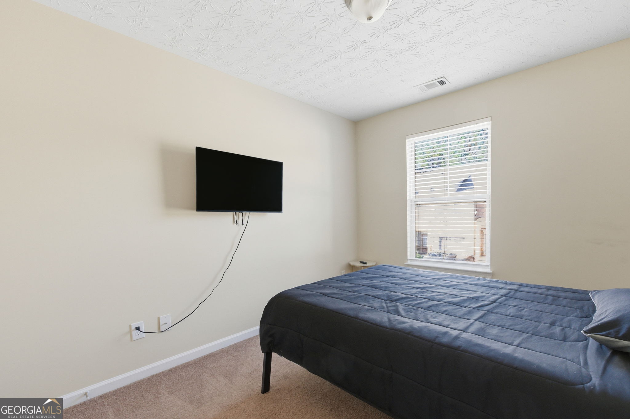 6022 Centennial Run Atlanta, GA 30349 - Photo 22 of 23 a bedroom with a bed and a flat screen tv