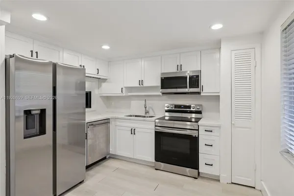 a kitchen with stainless steel appliances granite countertop a refrigerator stove and microwave
