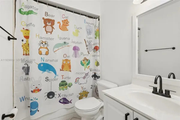 a bathroom with a sink a toilet and a shower curtain