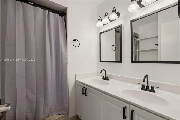 a bathroom with a double vanity sink and a mirror
