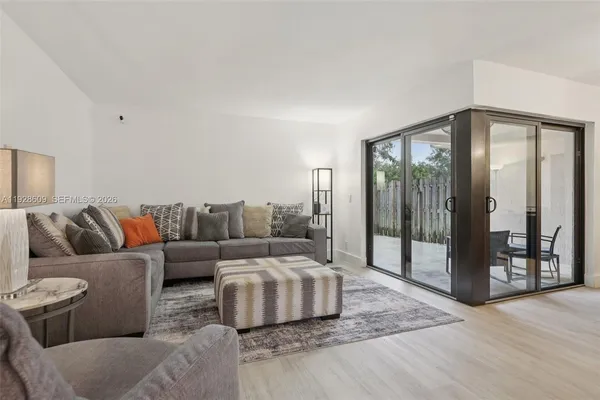 a living room with furniture and a floor to ceiling window