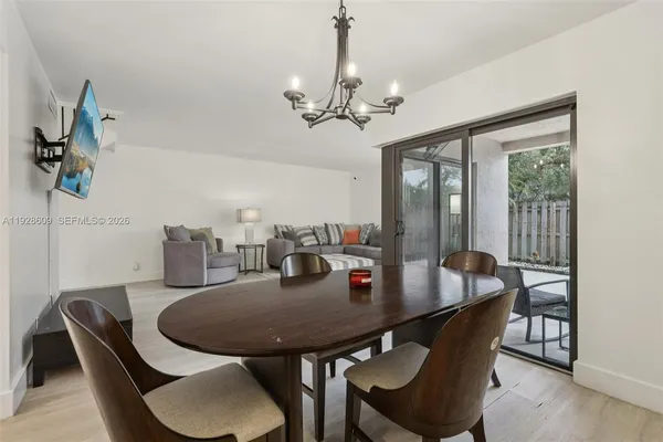 a view of a dining room with furniture and a chandelier