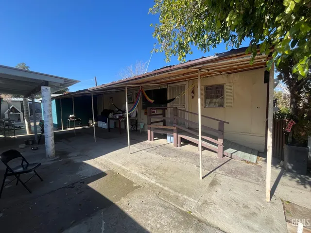 a view of a patio with table and chairs with wooden floor and fence