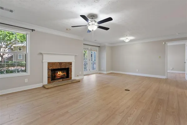 a view of an empty room with a fireplace and a window