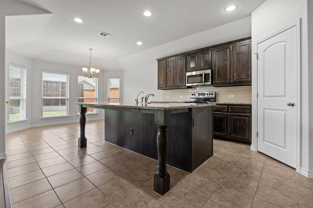 217 Angelina Court Azle, TX 76020 - Photo 12 of 34 a kitchen with stainless steel appliances granite countertop a sink stove and cabinets