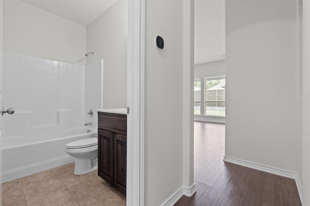 217 Angelina Court Azle, TX 76020 - Photo 17 of 34 a bathroom with a toilet a sink a shower and mirror