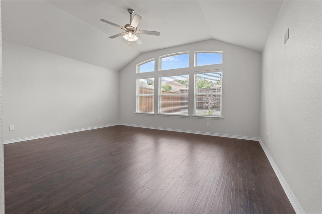 217 Angelina Court Azle, TX 76020 - Photo 21 of 34 an empty room with wooden floor chandelier fan and windows
