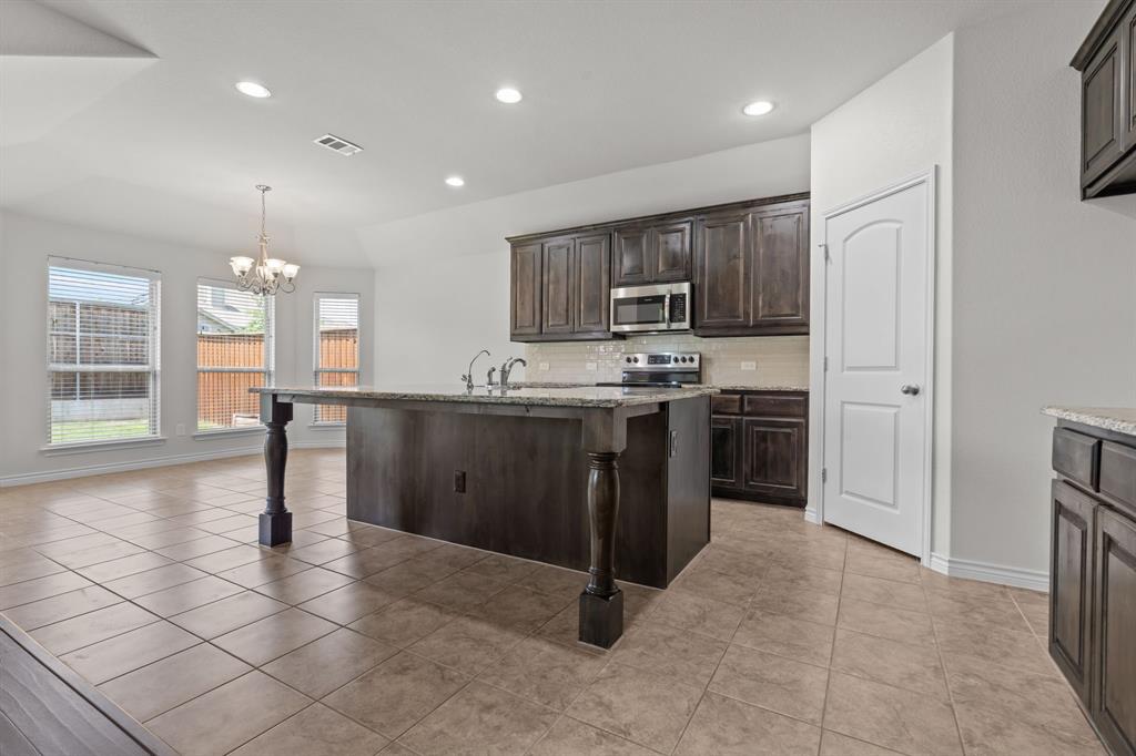 217 Angelina Court Azle, TX 76020 - Photo 8 of 34 a kitchen with stainless steel appliances granite countertop a stove a sink a refrigerator and a microwave