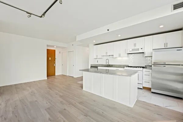 a kitchen with granite countertop white cabinets and white appliances