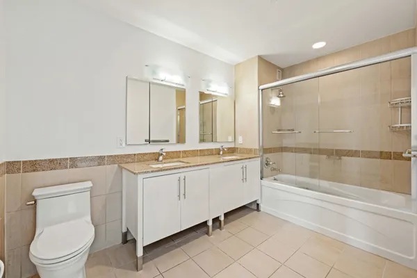 a bathroom with a granite countertop sink a toilet and bathtub