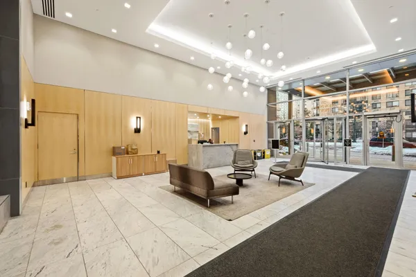 a living room with couches and kitchen view with wooden floor