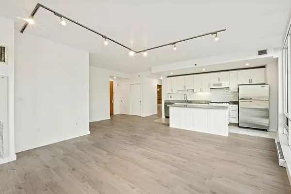 a view of kitchen refrigerator and cabinets