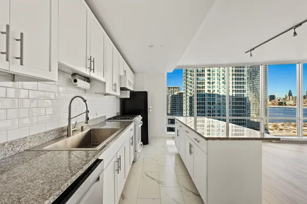 a kitchen with granite countertop a sink and a stove top oven