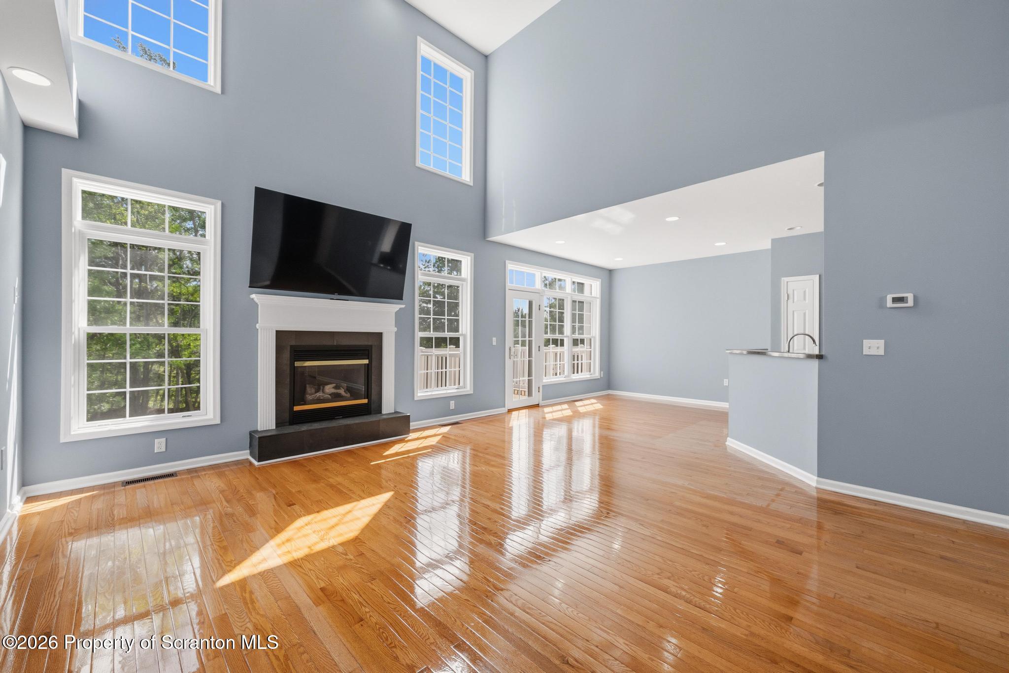 1502 Verne Cl Moosic, PA 18507 - Photo 6 of 46 a view of an empty room with wooden floor fireplace and a window