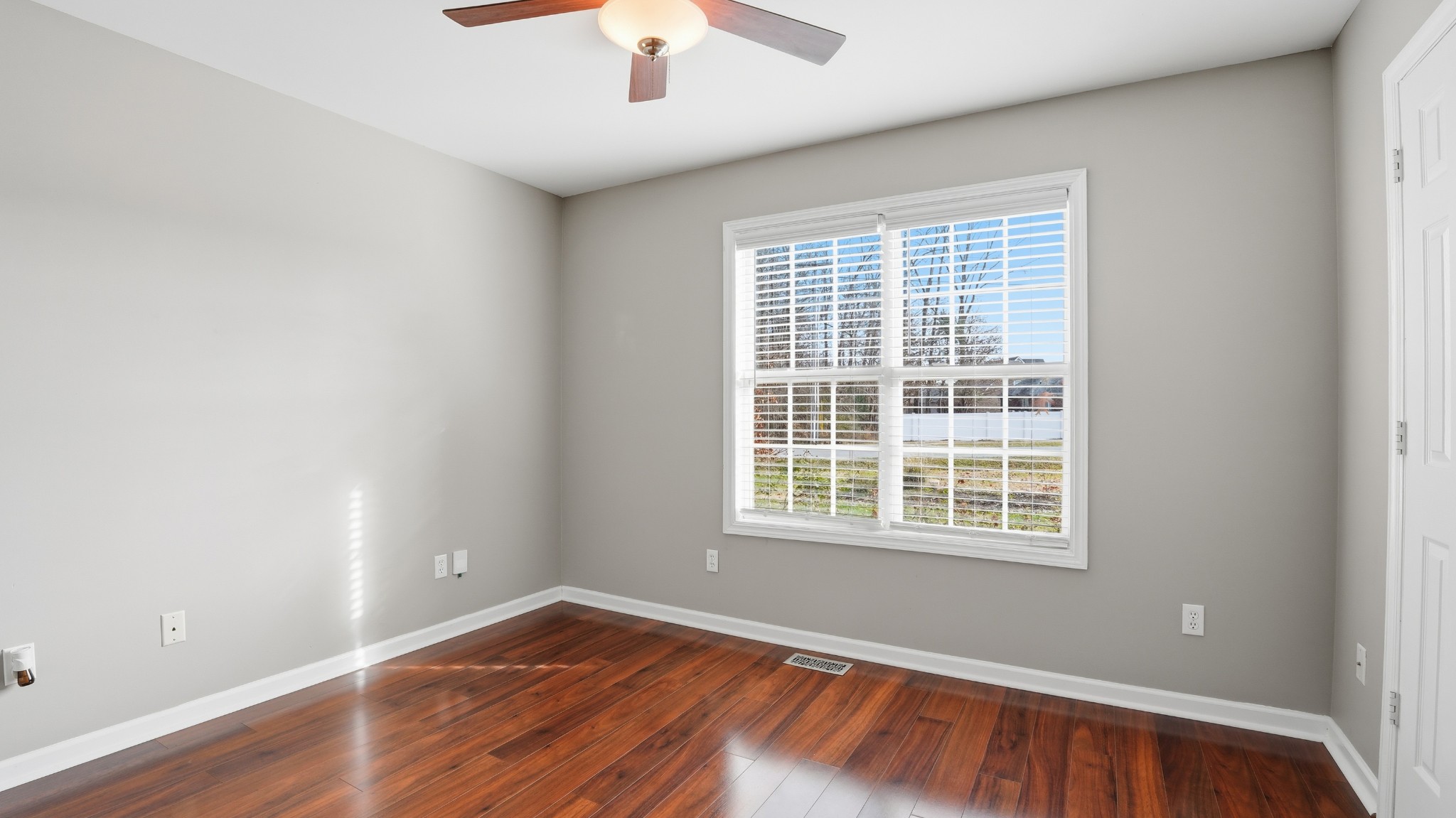 133 Riley Creek Road Tullahoma, TN 37388 - Photo 32 of 42 an empty room with wooden floor chandelier fan and windows