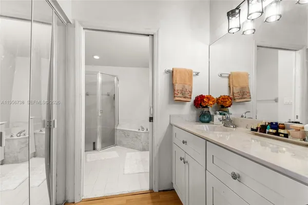 a bathroom with a double vanity sink mirror and shower
