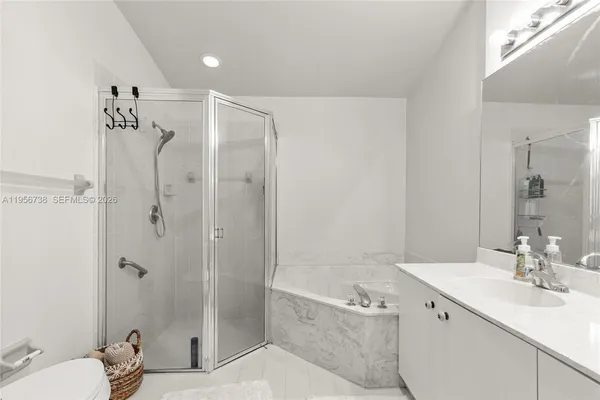 a bathroom with a bathtub shower sink mirror and toilet