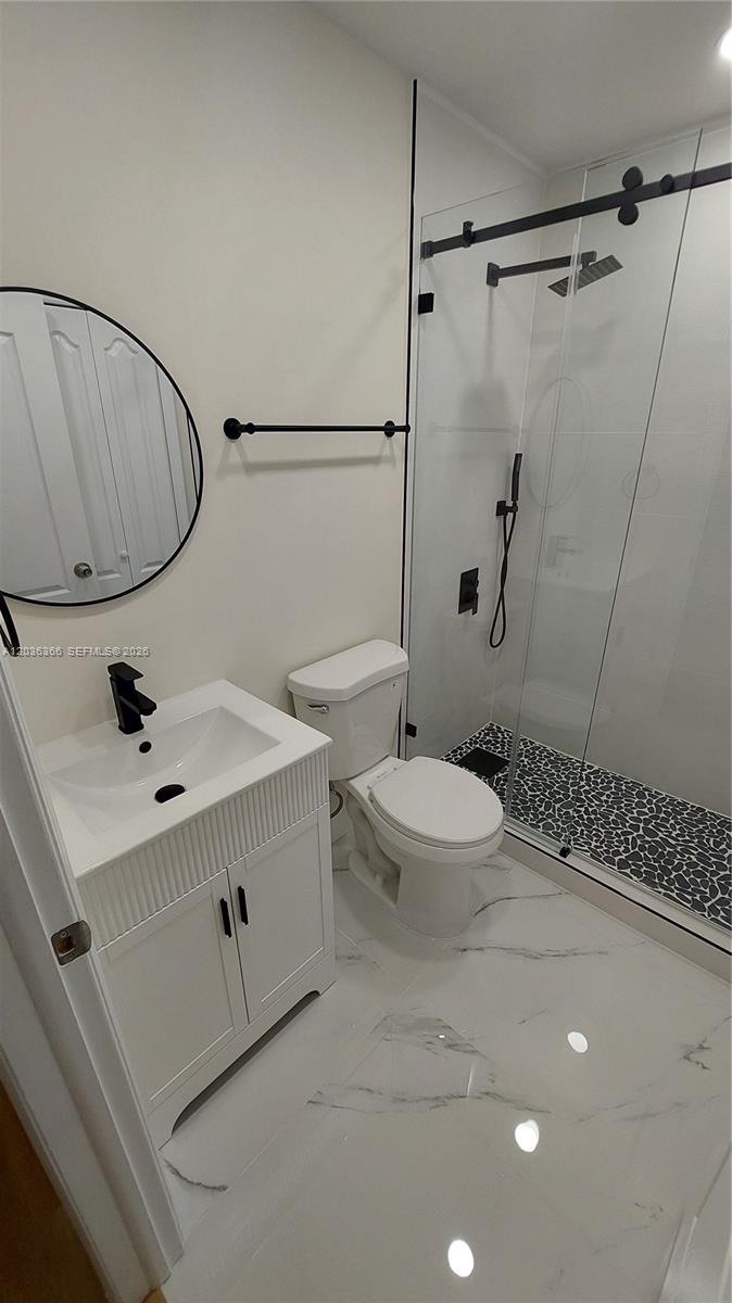 7083 Southwest 158th Court Miami, FL 33193 - Photo 22 of 22 a bathroom with a sink mirror vanity and toilet