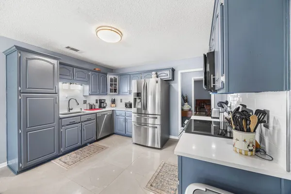 a kitchen with stainless steel appliances granite countertop a refrigerator sink and stove