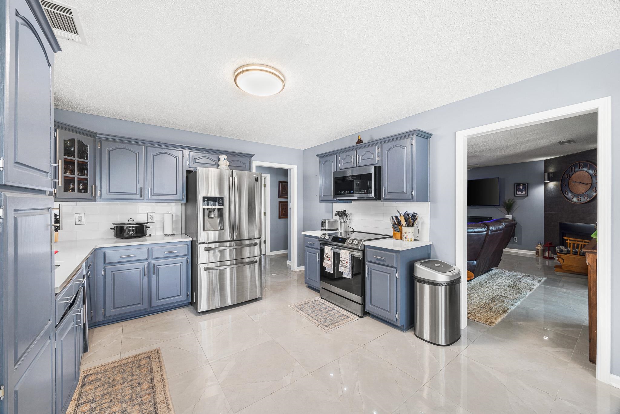 149 Abby Road Drummonds, TN 38023 - Photo 12 of 38 Kitchen with stainless steel appliances, backsplash, a textured ceiling, and light stone counters