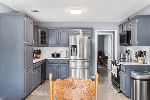 a kitchen with stainless steel appliances granite countertop a refrigerator stove and sink