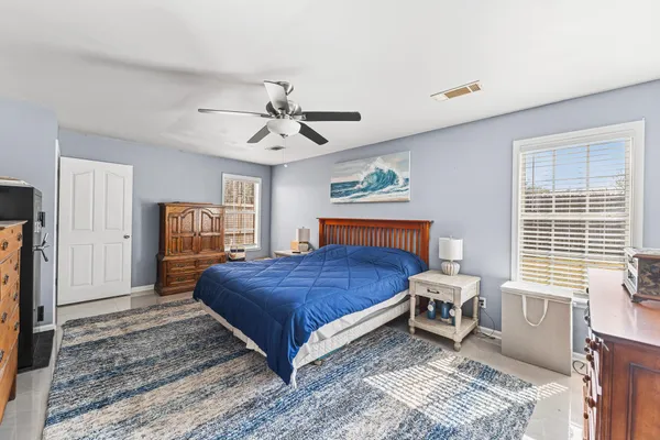 a bedroom with a bed a chandelier and dresser