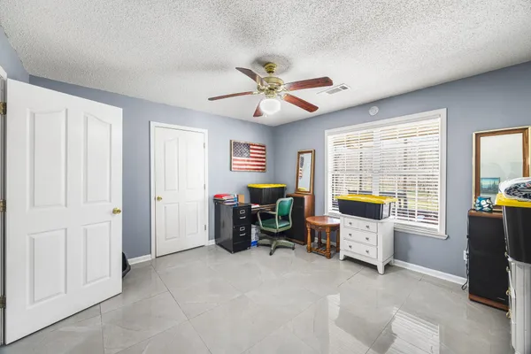 a living room with furniture a flat screen tv and a window