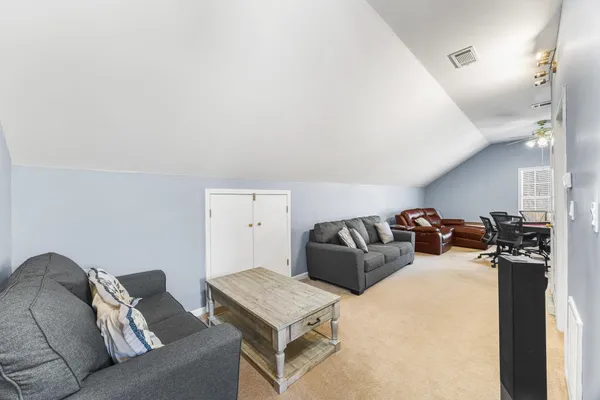 a living room with furniture a bed and a flat screen tv