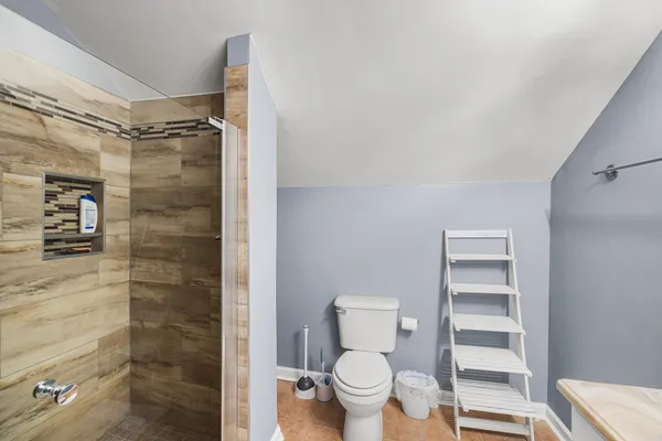 a bathroom with a toilet and a shower