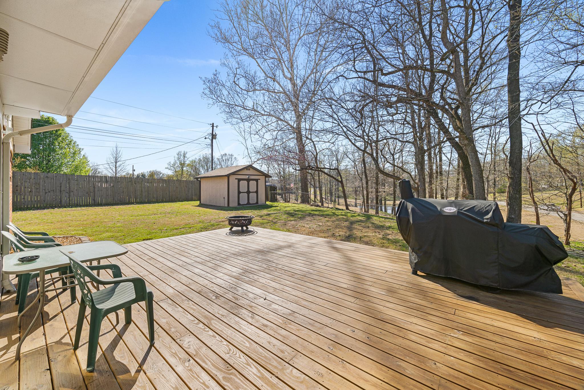 149 Abby Road Drummonds, TN 38023 - Photo 33 of 38 Deck with an outdoor fire pit, a storage shed, and a fenced backyard