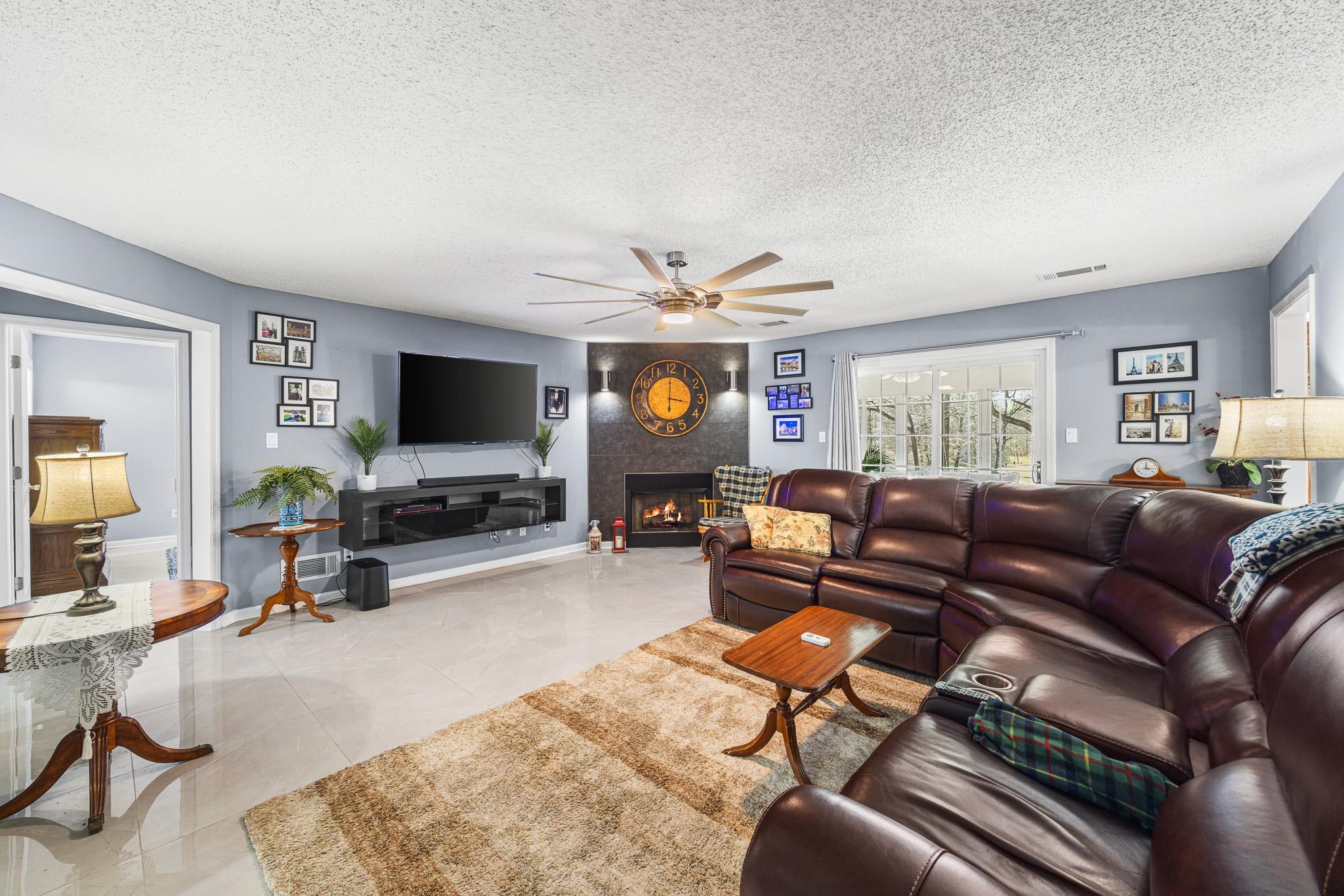 149 Abby Road Drummonds, TN 38023 - Photo 6 of 38 Living area with a ceiling fan, a fireplace, and a textured ceiling