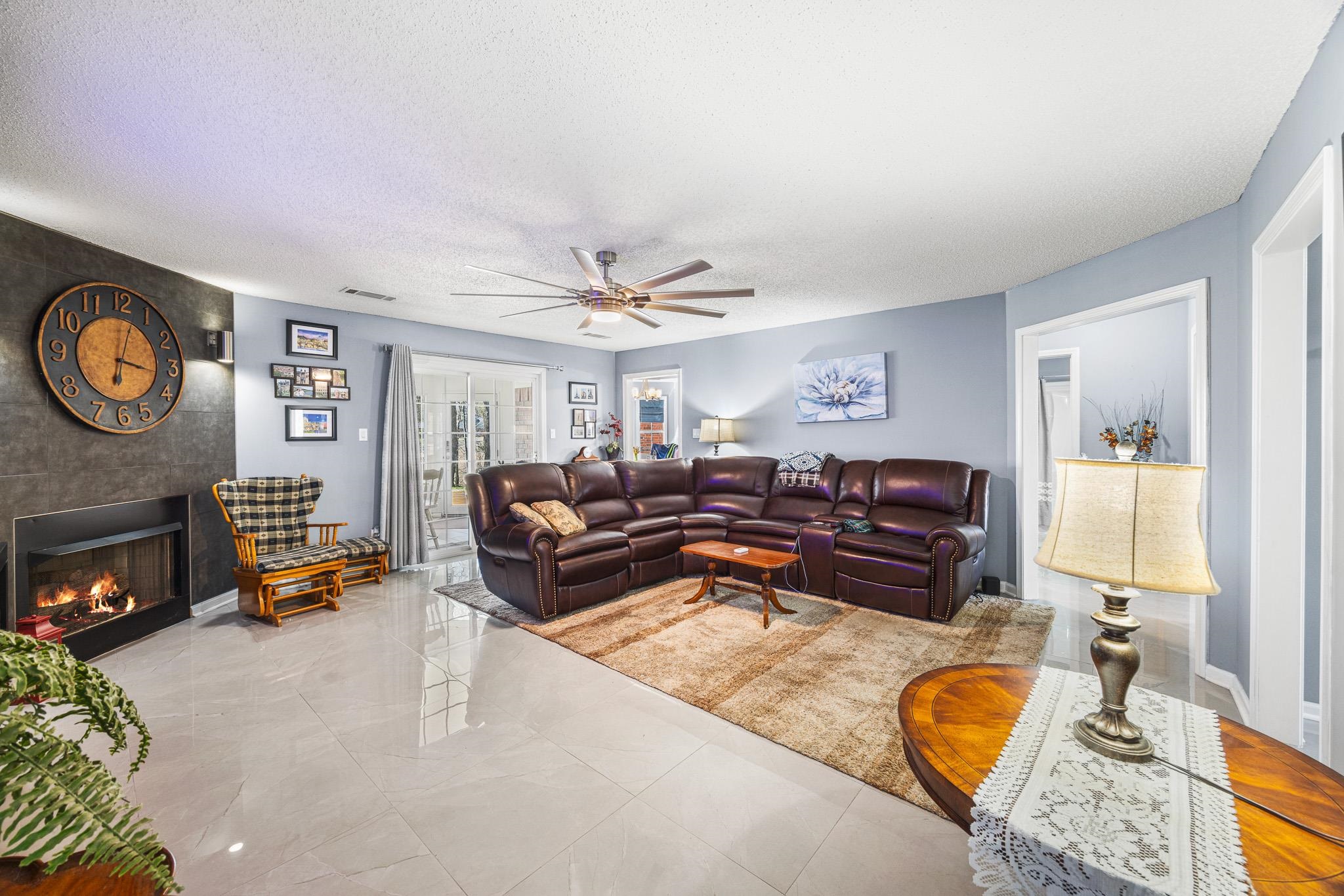 149 Abby Road Drummonds, TN 38023 - Photo 7 of 38 Living area with a textured ceiling, a ceiling fan, and a large fireplace