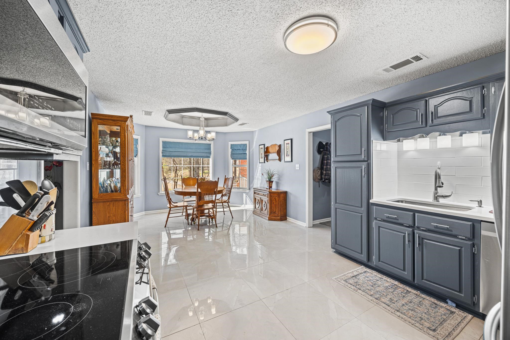 149 Abby Road Drummonds, TN 38023 - Photo 10 of 38 Kitchen with electric stove, exhaust hood, a textured ceiling, backsplash, and light stone countertops