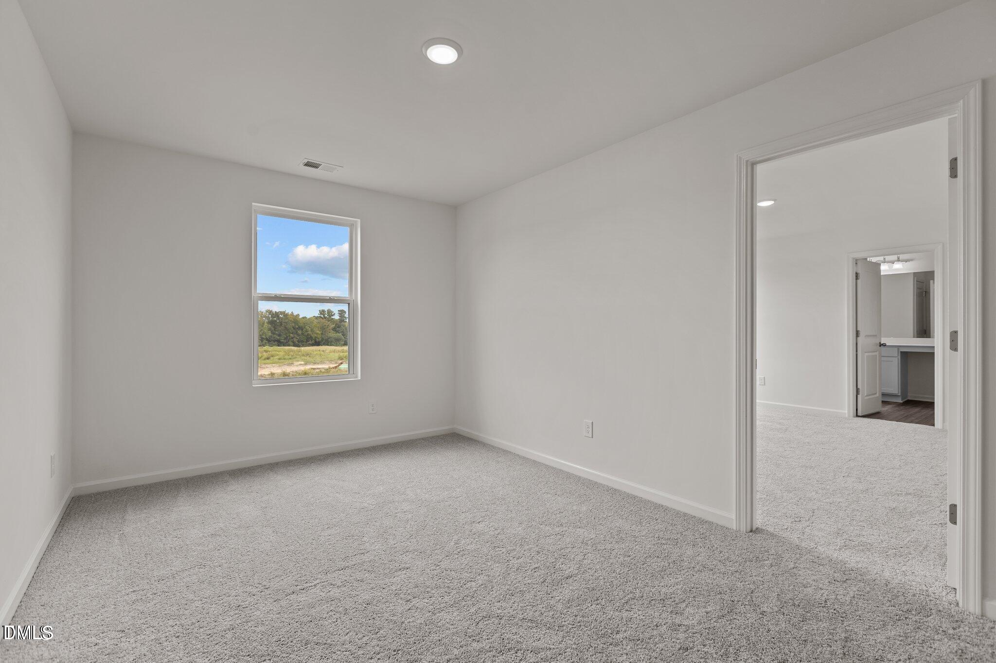 149 Bedstone Way Clayton, NC 27520 - Photo 15 of 22 an empty room with a window and a kitchen