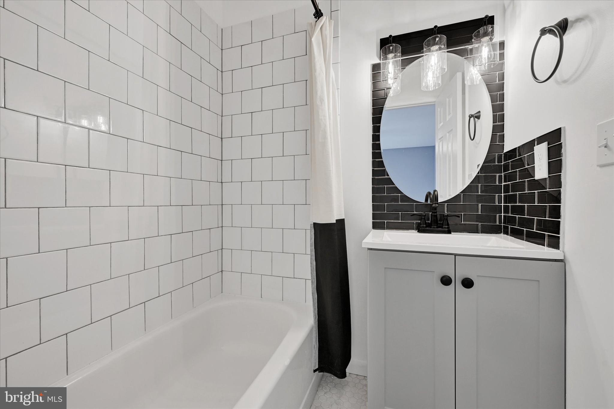 21 Allison Way Abingdon, MD 21009 - Photo 16 of 26 a bathroom with a bathtub a mirror a vanity and a shower