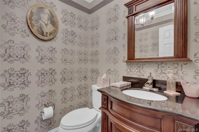 a bathroom with a granite countertop toilet sink and mirror