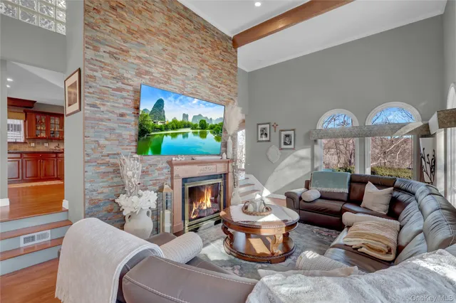 a living room with furniture a fireplace and a flat screen tv