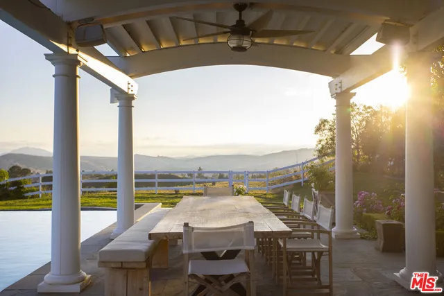 a view of a chair and tables in the patio next to a yard