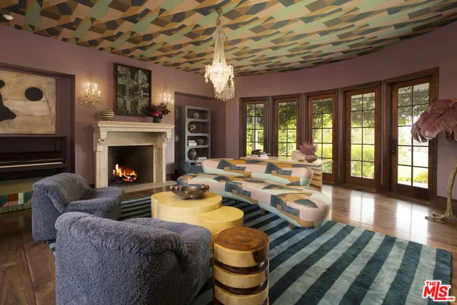 a living room with fireplace furniture and a large window