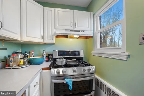 a kitchen with a stove and white cabinets