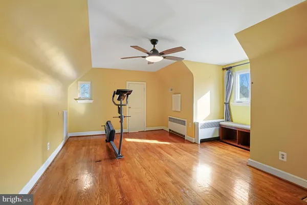 a view of a room with gym equipment and wooden floor