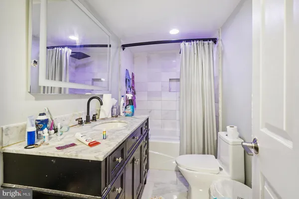 a bathroom with a sink vanity mirror and toilet
