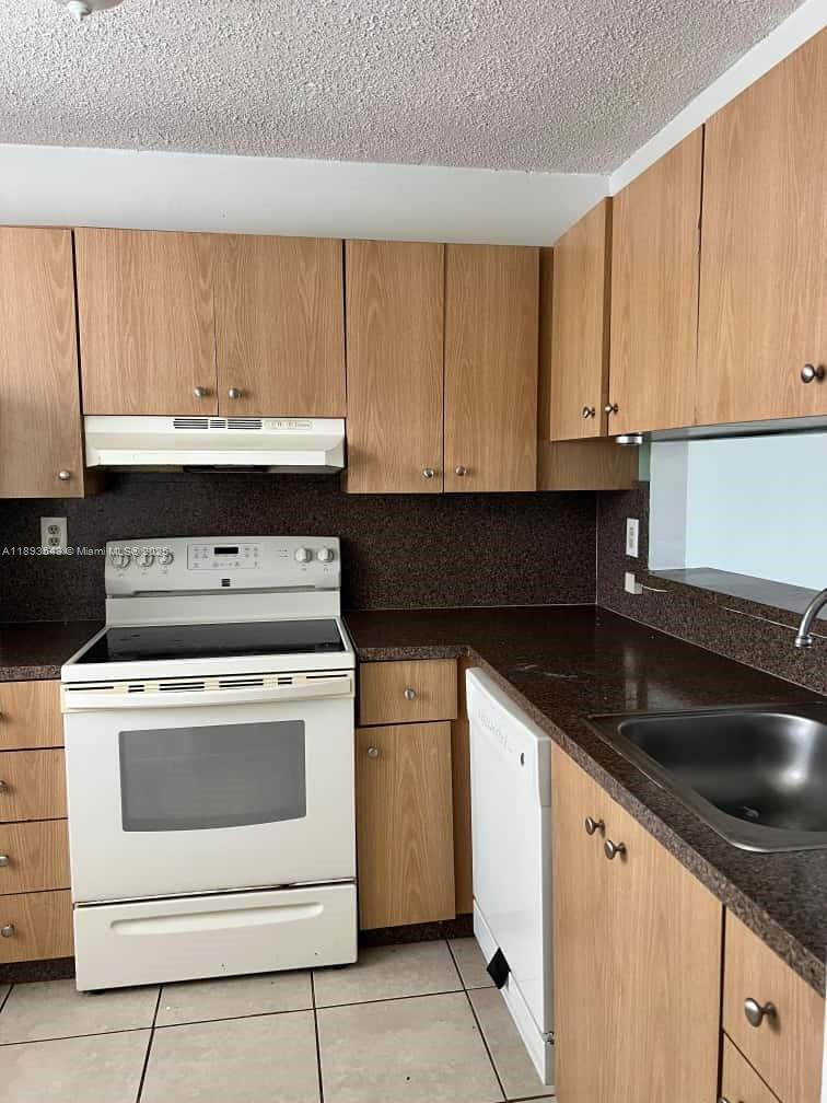 3470 Foxcroft Road, Unit 307 Miramar, FL 33025 - Photo 6 of 12 a kitchen with granite countertop cabinets stainless steel appliances and a sink